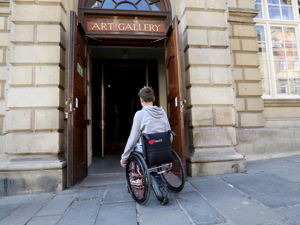 Image: A wheelchair user entering the Gallery through the accessible entrance