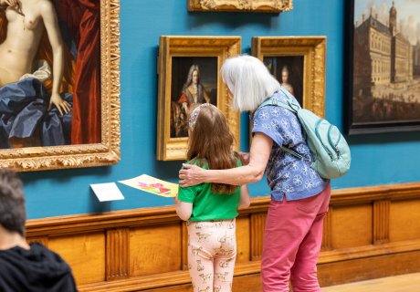 An adult and child looking at paintings in the Upper Gallery