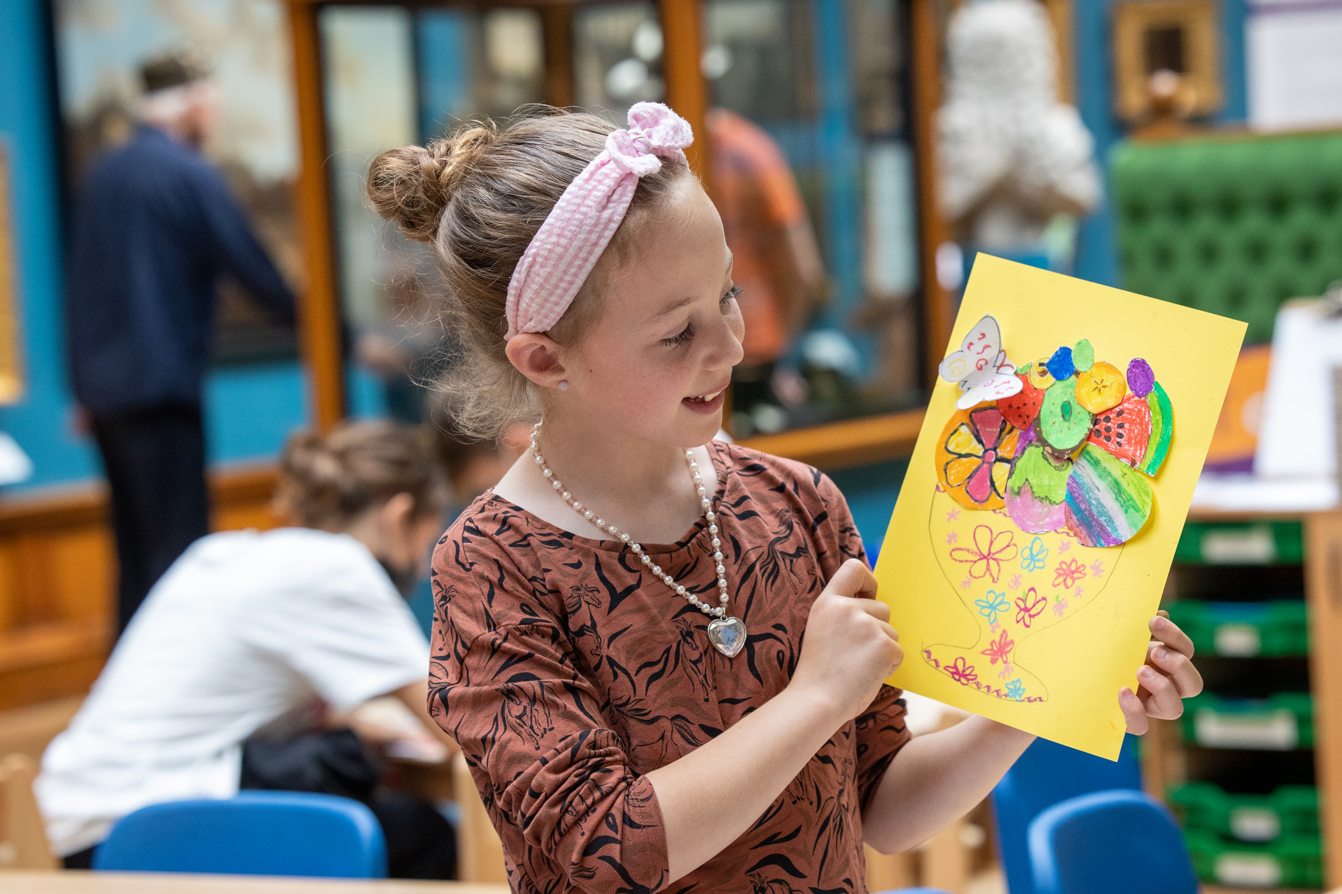Image: A child looking at an artwork she has made