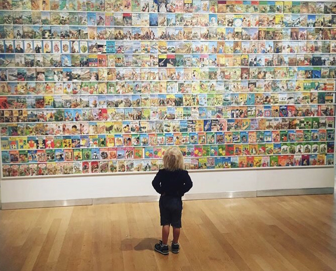 A child looking at a wall of Ladybird books