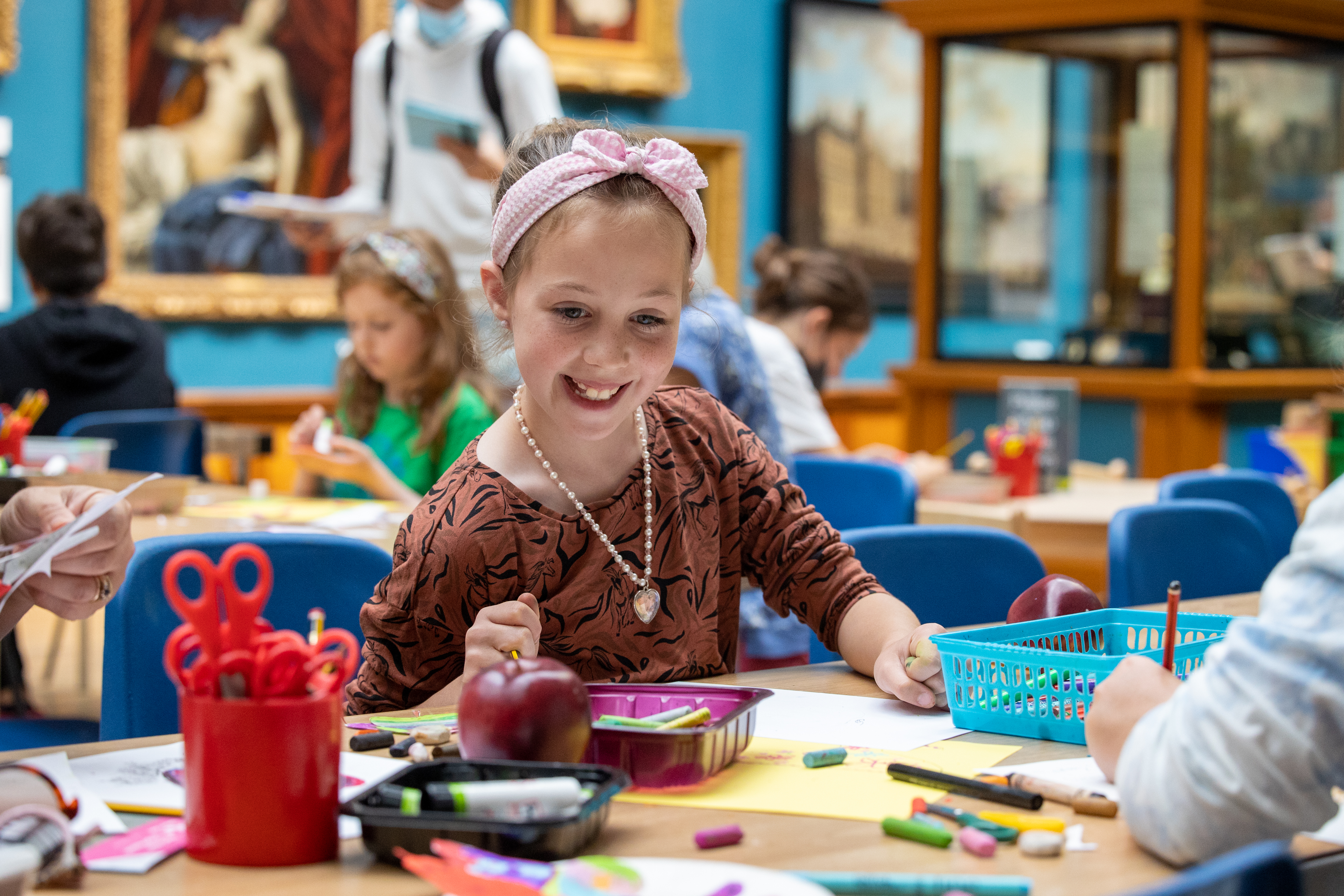 A girl sitting at a table with craft activities in the Victoria Art Gallery