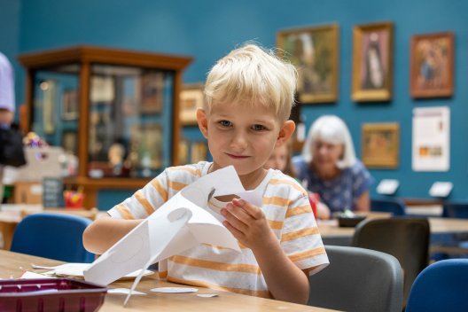 A boy cutting paper in the Victoria Art Gallery